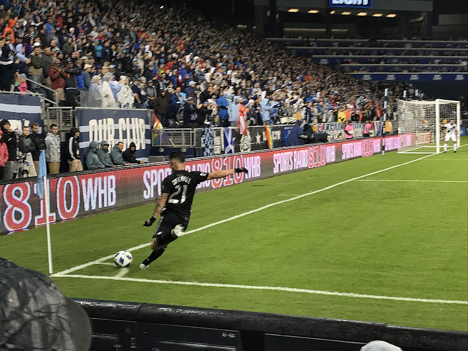Futbolista ejecuta un saque de esquina en un estadio